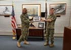 Command Master Chief Greg Vidaurri (left, wearing mask) for U.S. Navy Region accepts a token of appreciation from Rear Adm. Robert B. Chadwick, commander of Navy Region Hawaii.