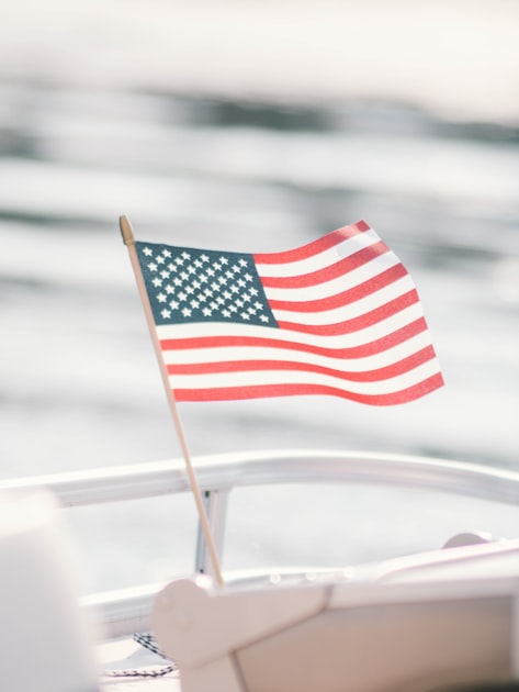 American flag on a boat railing with a bright, blurred backdrop