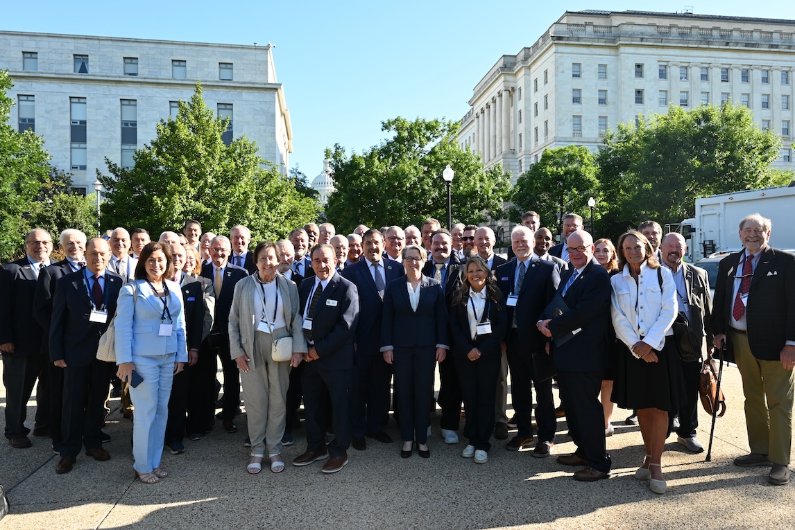 A group of people posing with the US Capitol Building in the background.