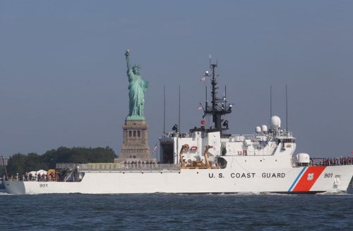 A U.S. Coast Guard cutter travels past the Statue of Liberty
